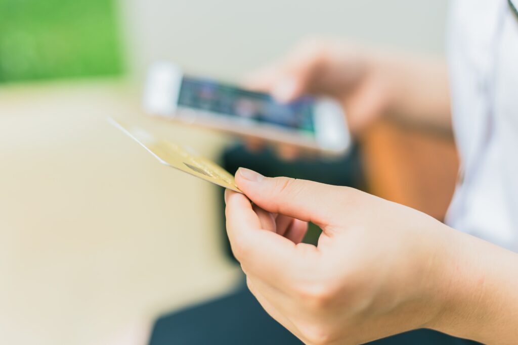 Person entering credit card details using their phone keypad.